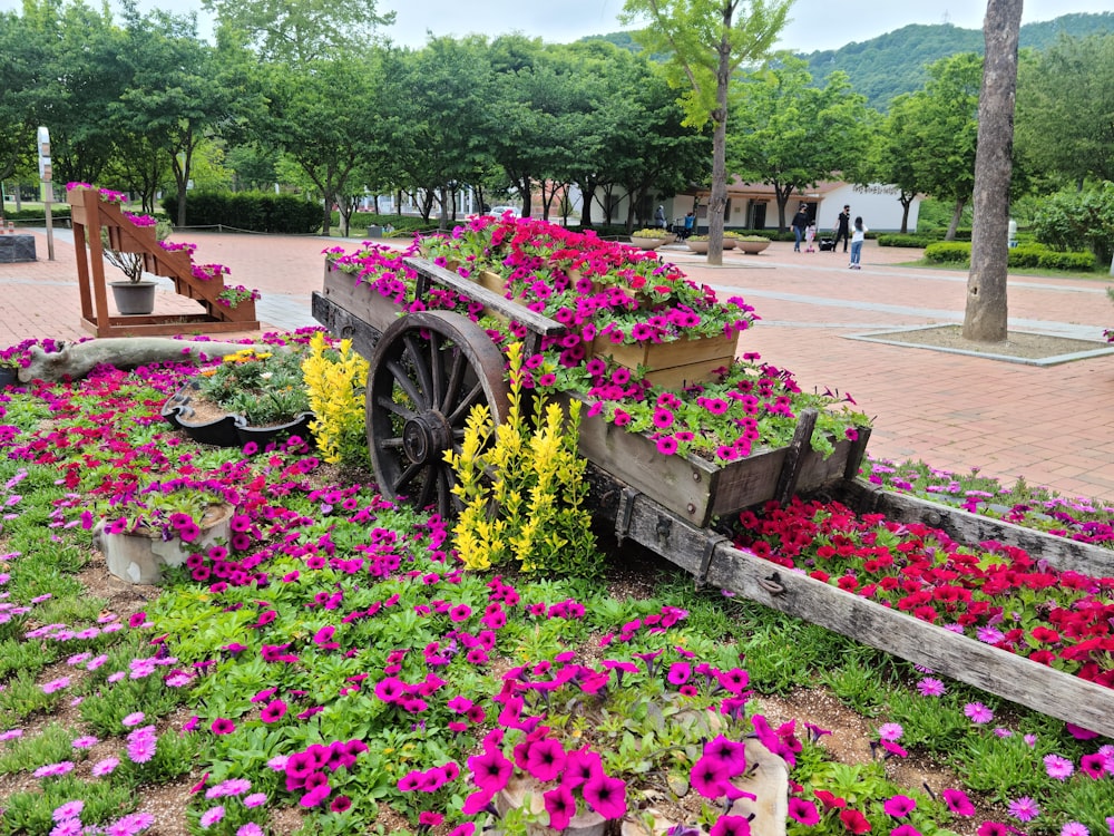 a wagon filled with flowers sitting on top of a lush green field