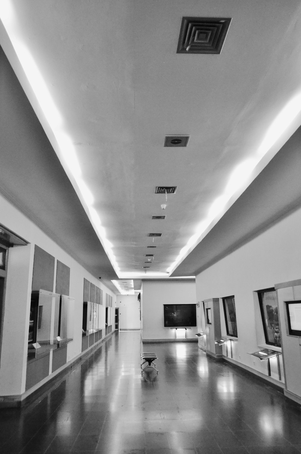 a black and white photo of a long hallway