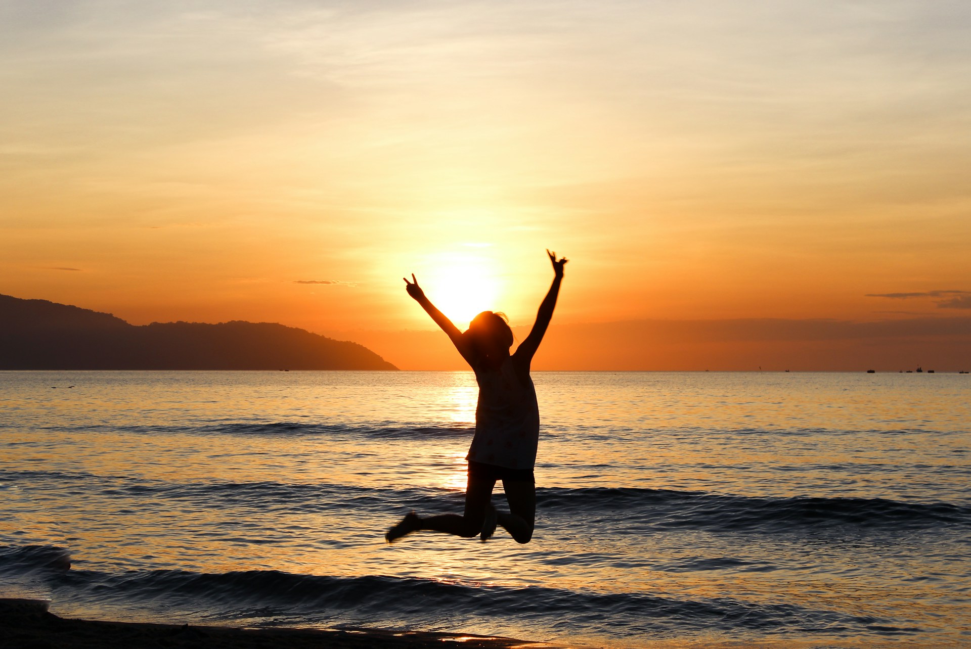 a person jumping into the air on a beach