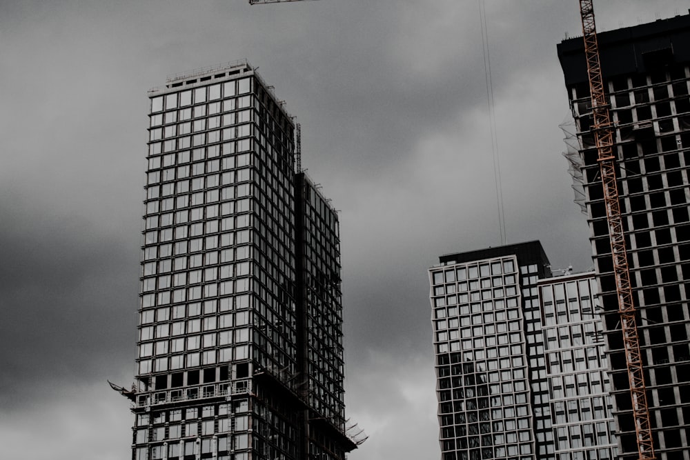 a crane is in the air over some tall buildings