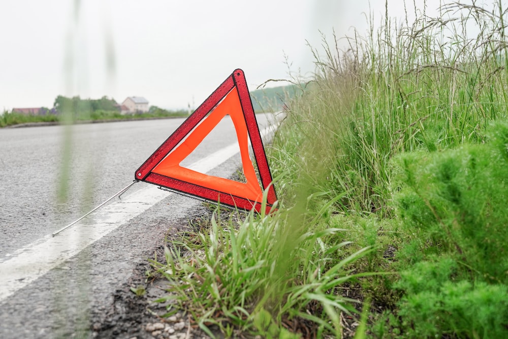 a red triangle sign sitting on the side of a road