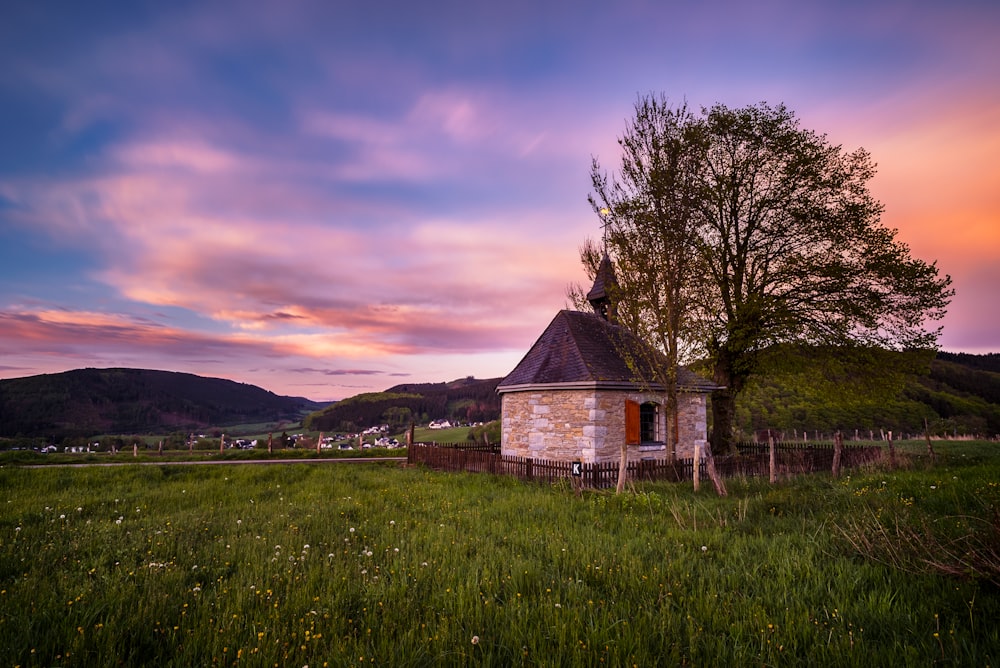 a small building in the middle of a field