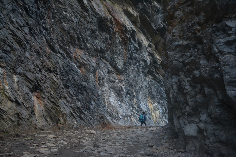 a person walking down a rocky path in the mountains
