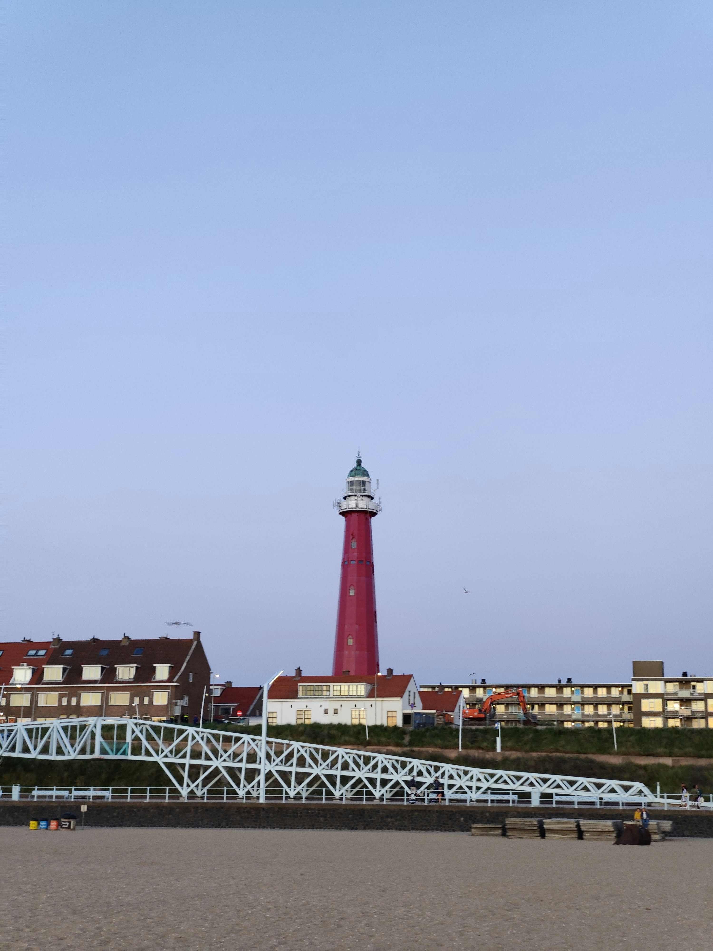 Phare rouge et blanc près du plan d’eau pendant la journée