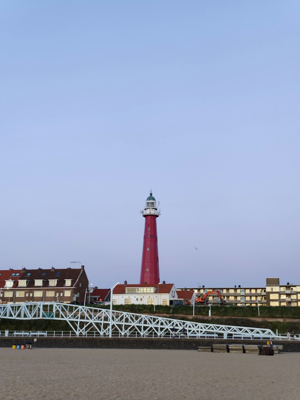 red and white lighthouse near body of water during daytime