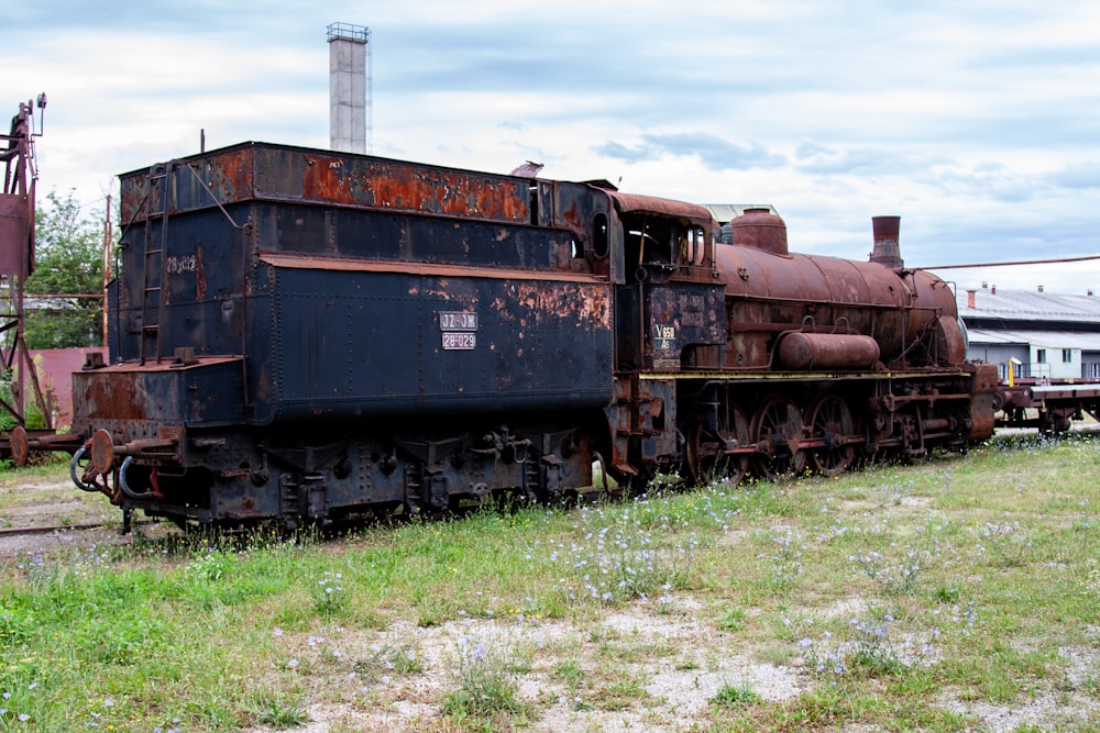 an old rusty train sitting on the tracks