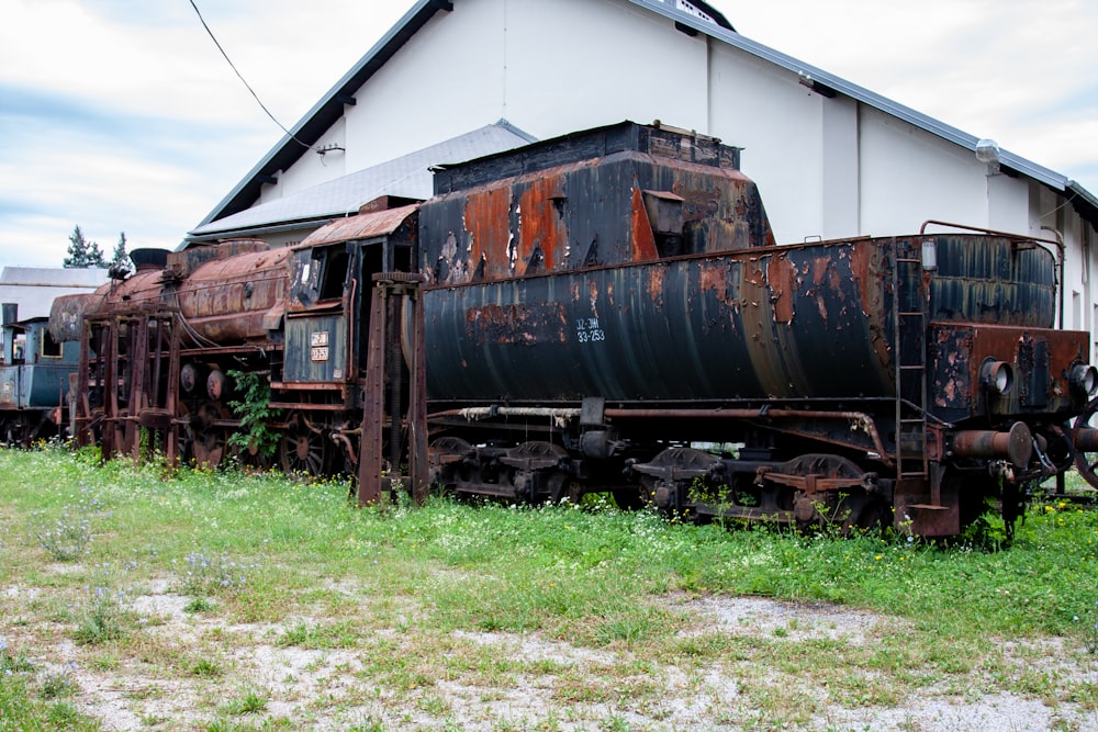 a rusted out train sitting in front of a building
