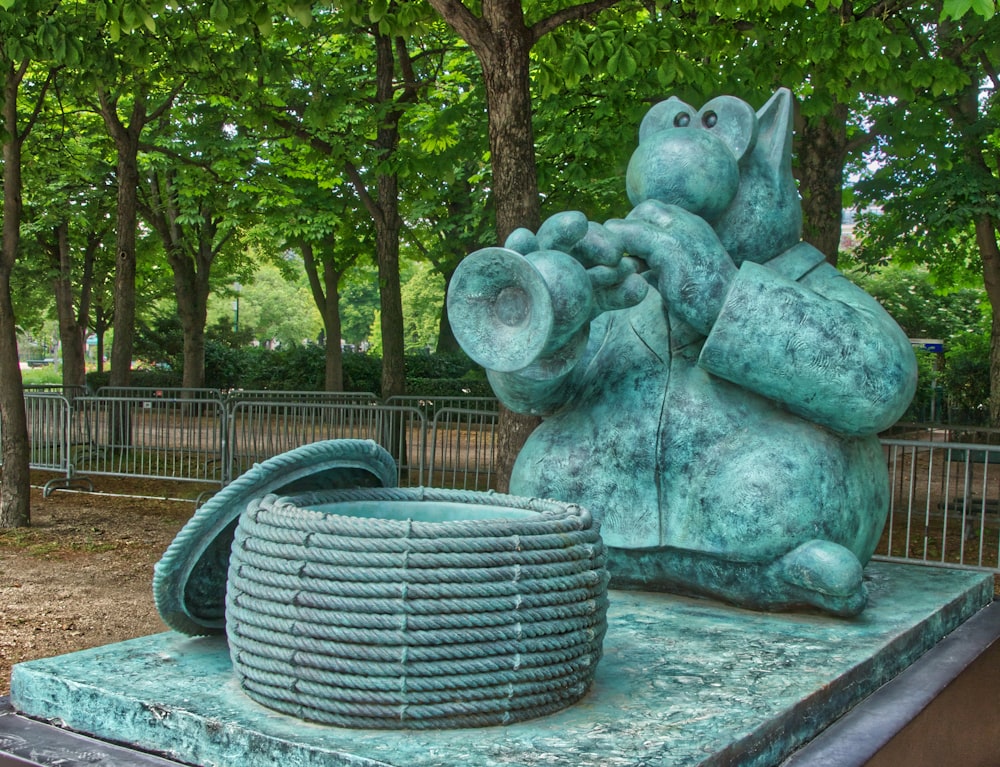 a statue of a rat holding a coiled object