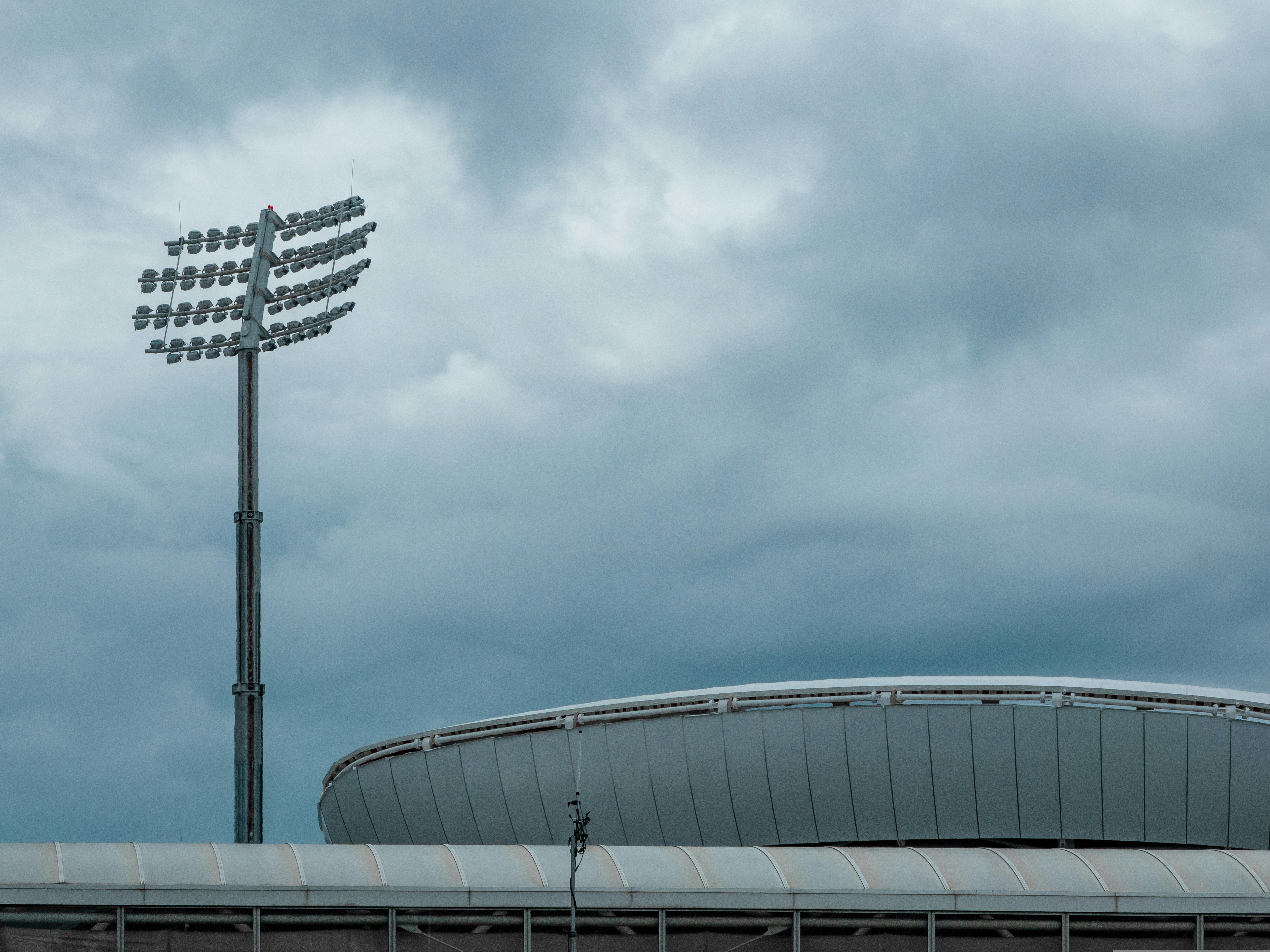 modern sports stadium seating bowl with cellular antenna masts mounted on lighting rig