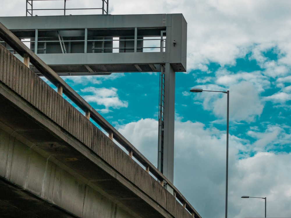 a traffic light on a metal pole next to a bridge