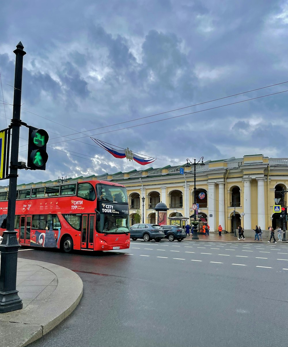 a red double decker bus driving down a street