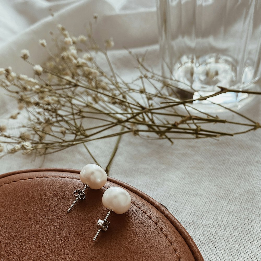 a pair of pearl earrings sitting on top of a table