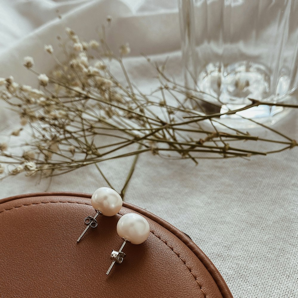 A pair of pearl earrings sitting on top of a table photo – Free