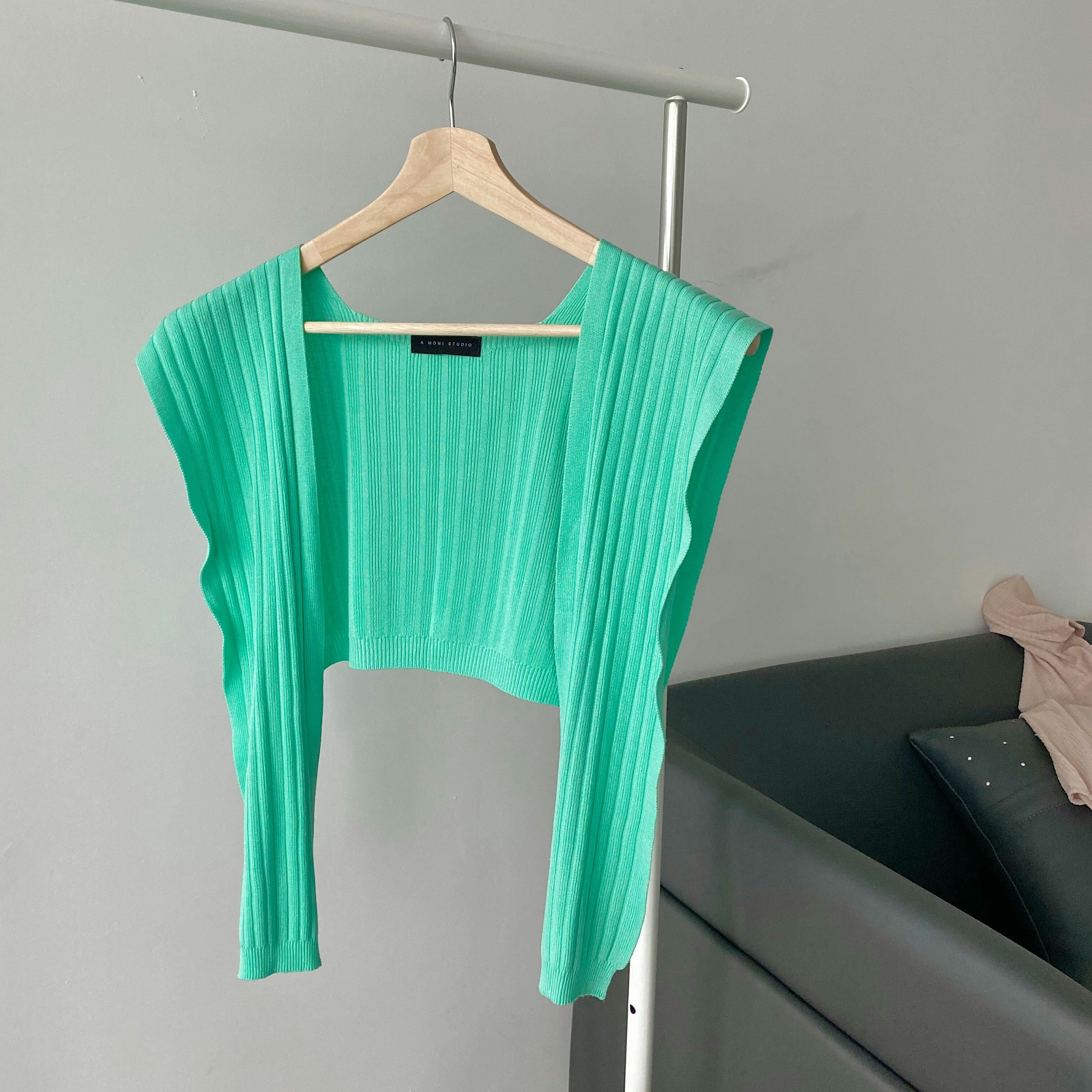 Blush merino ribbed knit sweater hanging on minimal wooden hanger