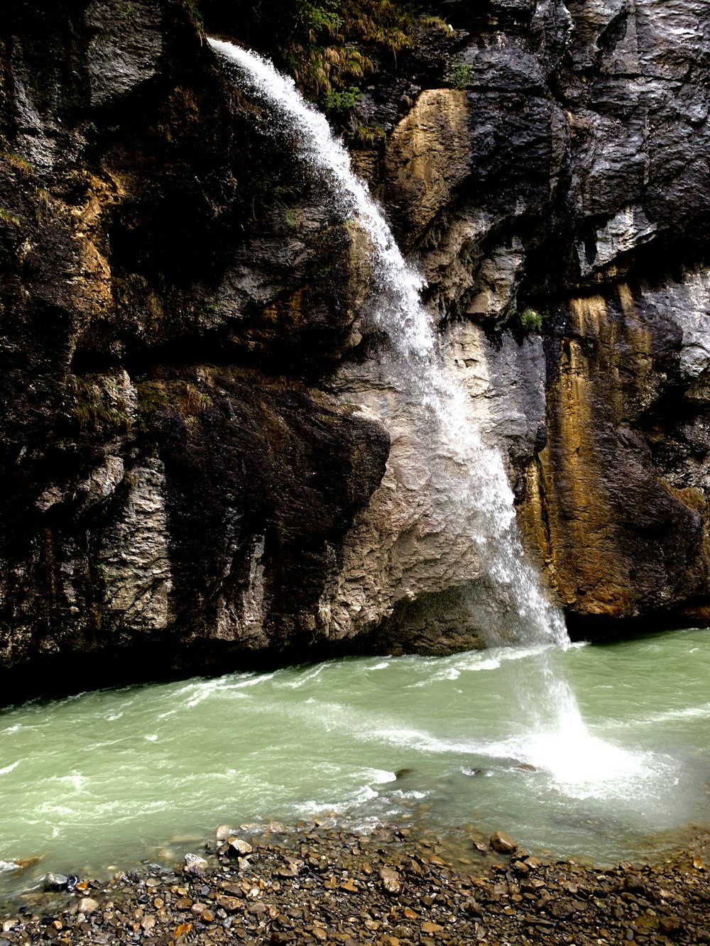 a man standing in front of a waterfall