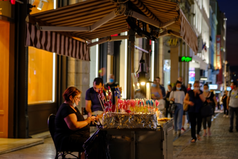 a woman sitting at a table in front of a store