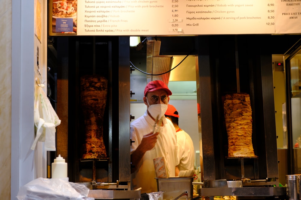 um homem com o uniforme de um chef em pé na frente de um balcão