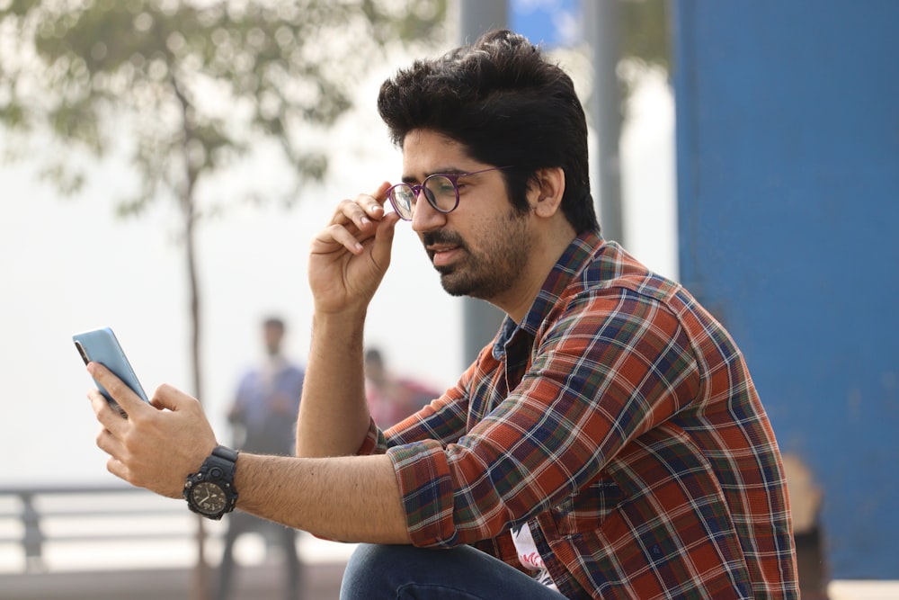 a man sitting on a bench looking at his cell phone