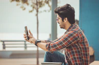 A candid shot of a person reading an AI blog on a smartphone in a park.