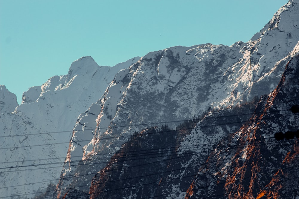 a snow covered mountain with a telephone pole in the foreground