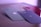 Four smartphone cases with camera cutouts are arranged on a flat surface. The cases are in various colors: green, beige, red, and black, each featuring a logo of a bitten apple. The lighting gives a soft purple hue to the scene.