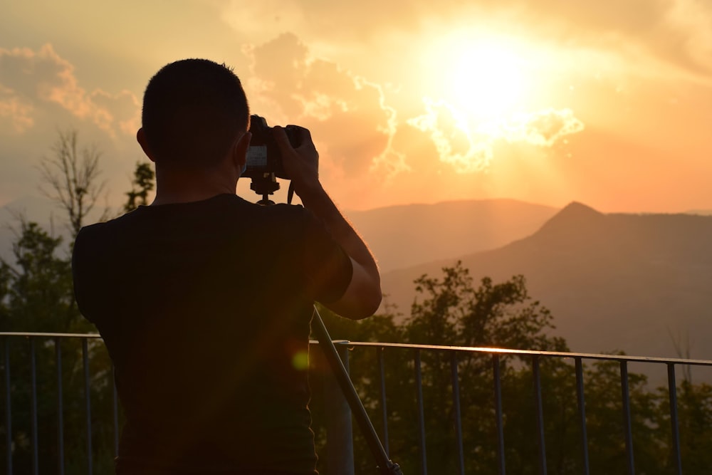 Un uomo che scatta una foto del sole con una macchina fotografica