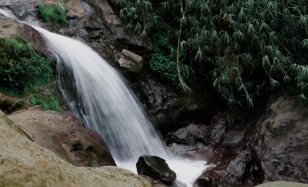 a small waterfall in the middle of a rocky area