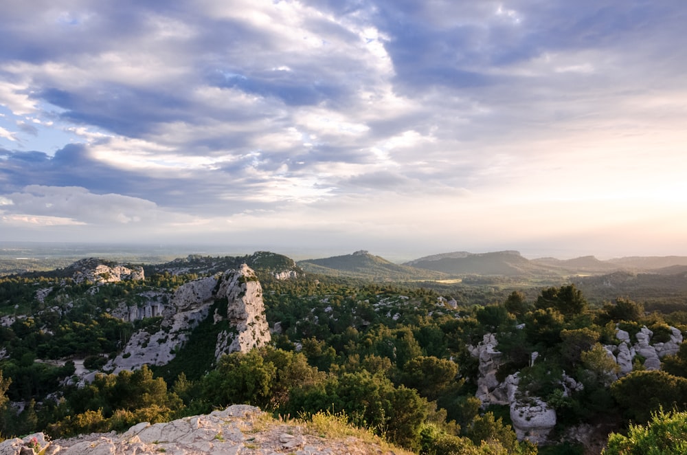 Ein malerischer Blick auf ein Tal mit Bäumen und Bergen im Hintergrund