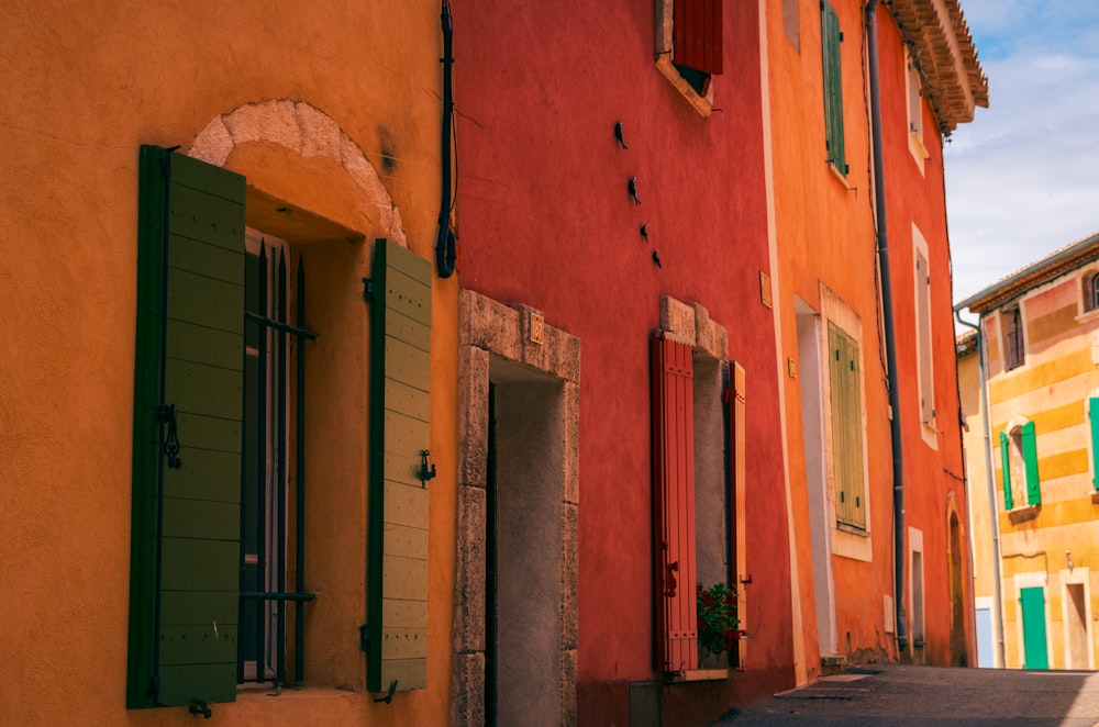 a row of colorful buildings with green shutters