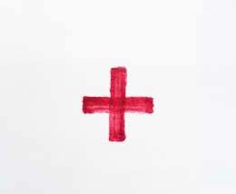 a red cross painted on a white paper