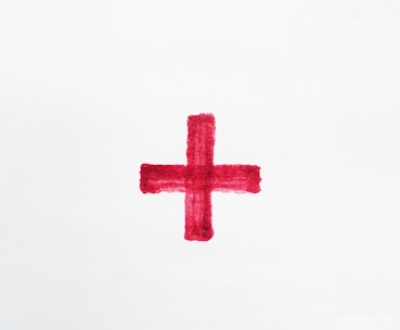 a red cross painted on a white paper