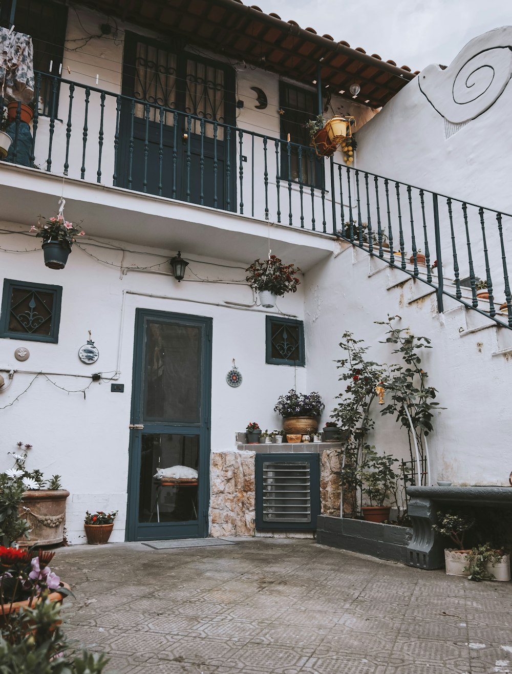 Un edificio blanco con una puerta azul y un balcón