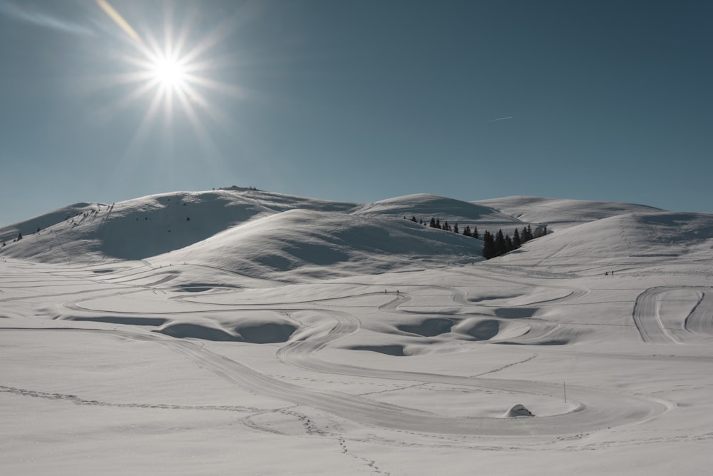 the sun is shining over a snowy mountain