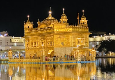 the golden building is reflected in the water