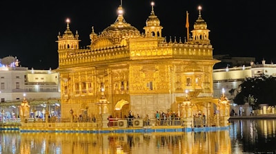 the golden building is reflected in the water