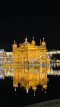 The Golden Temple illuminated at night, reflecting in the dark water in Amritsar