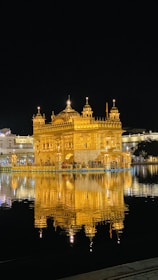 the golden building is reflected in the water