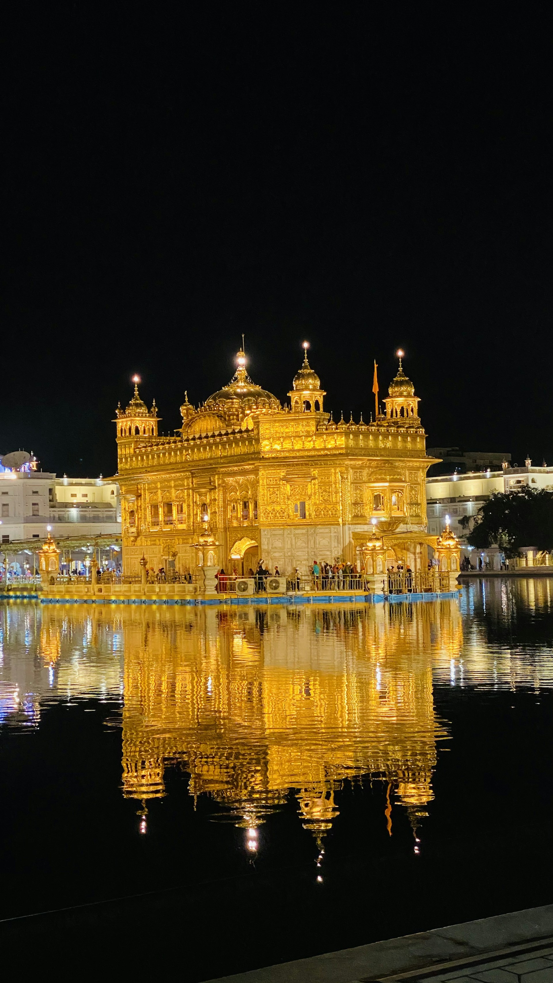 the golden building is reflected in the water