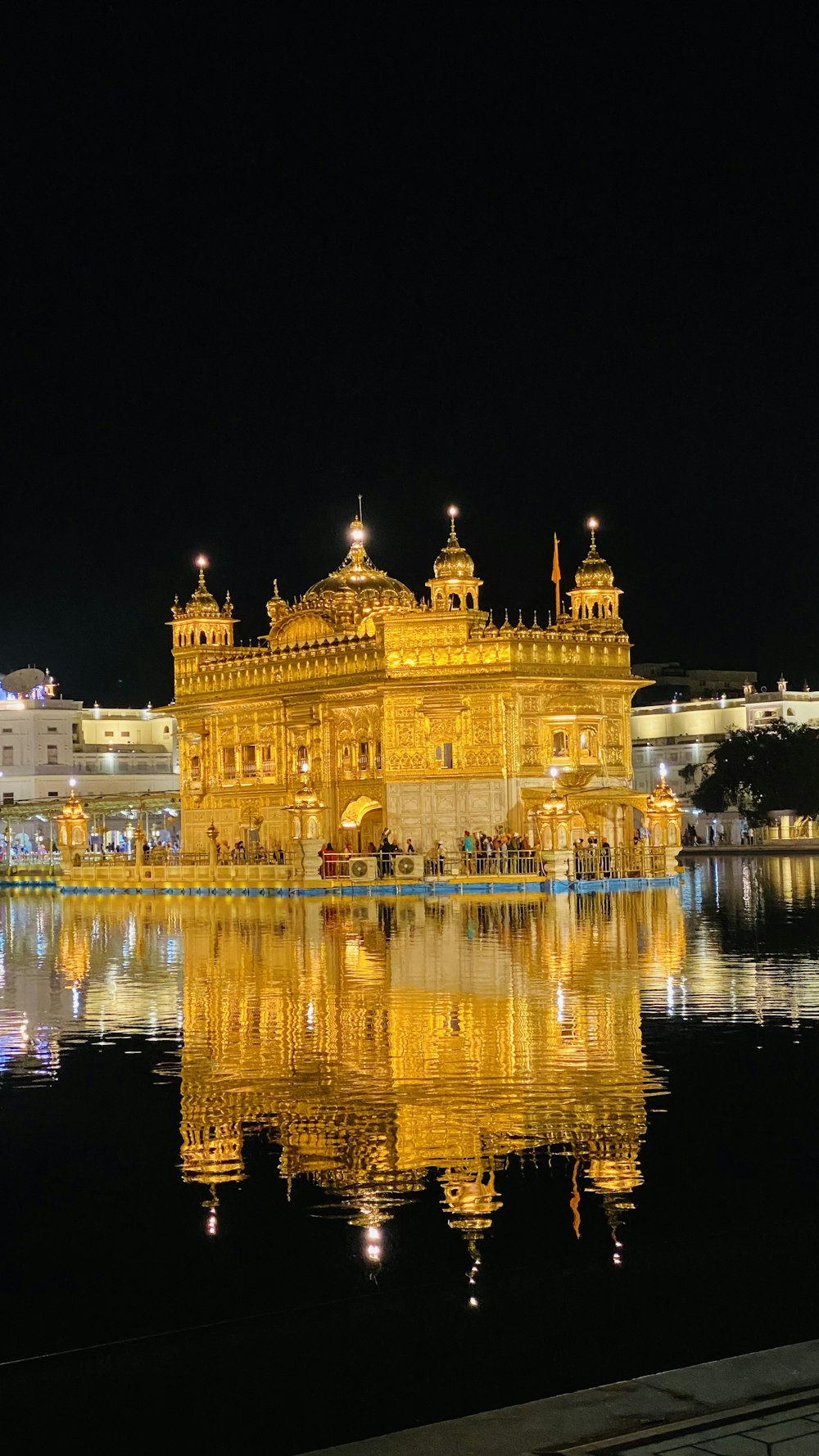 the golden building is reflected in the water