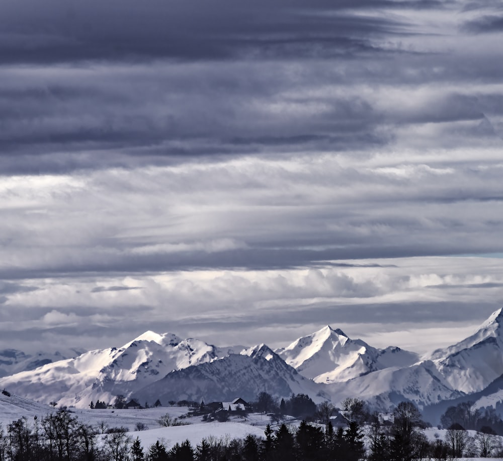 montañas cubiertas de nieve bajo el cielo nublado durante el día