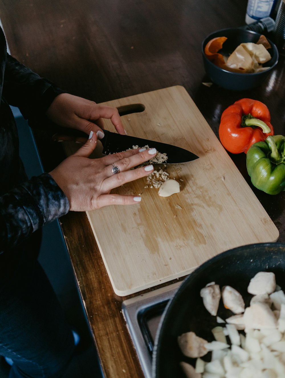 person holding red tomato beside red and green bell pepper