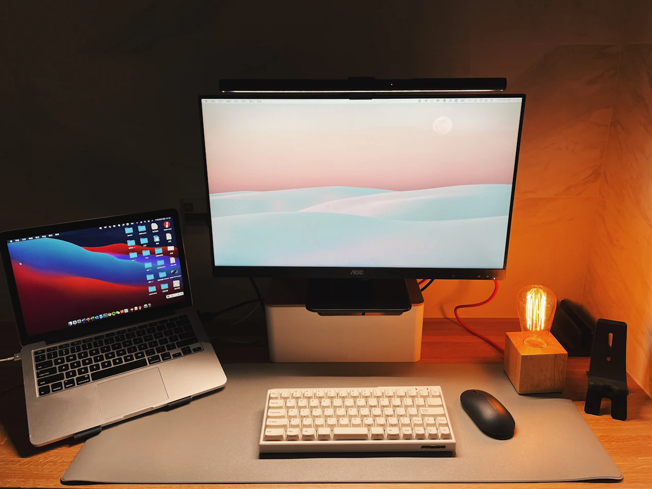 Laptop and monitor on a wooden desk in a quiet workspace.