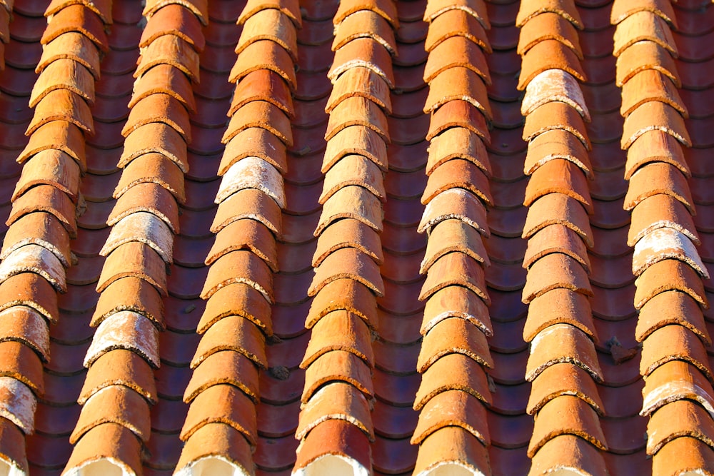 a close up of a roof with a red tile pattern