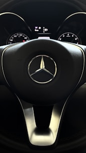 Close-up of a Mercedes-Benz steering wheel with a GPS screen showing a map.