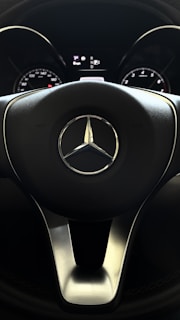 Close-up of a technician carefully performing SCN coding on a Mercedes dashboard inside a sleek workshop.