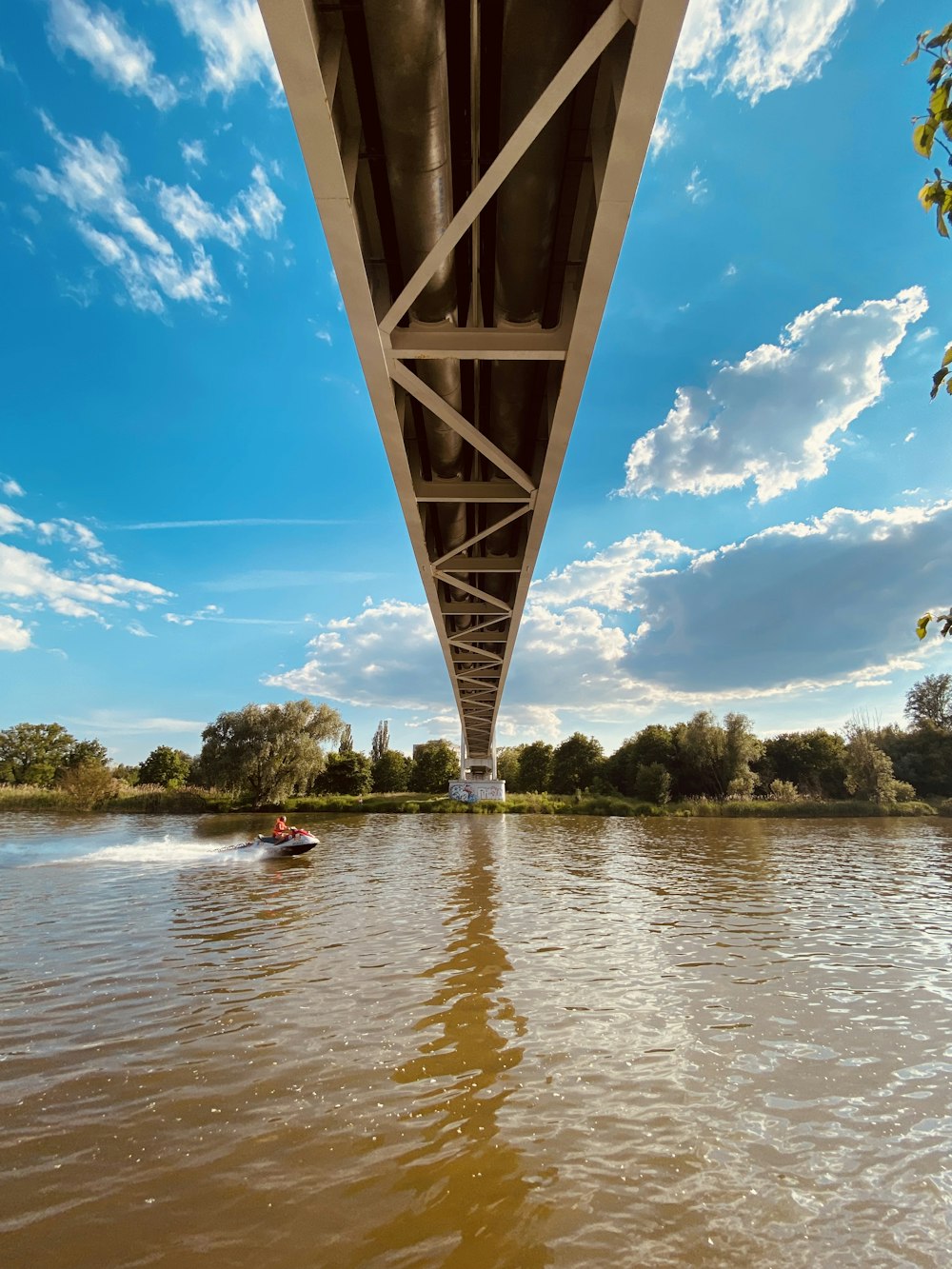 un barco que viaja bajo un puente sobre un río