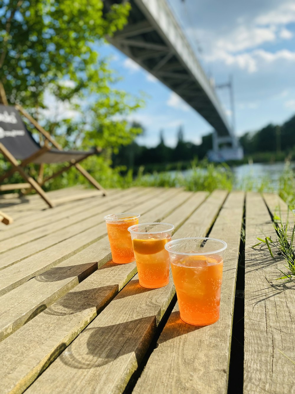 three glasses of orange juice sitting on a wooden table