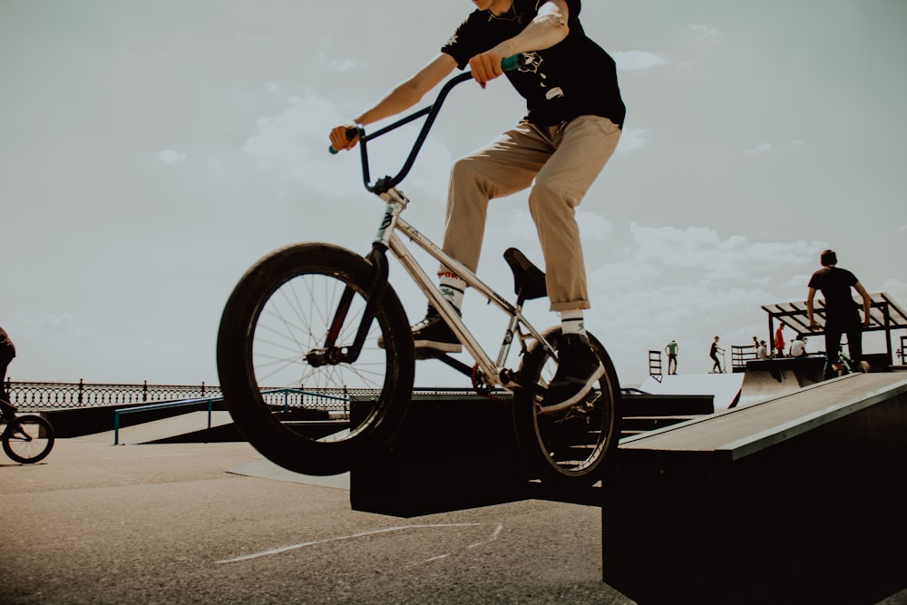 A man jumping through the air while riding his BMX bicycle
