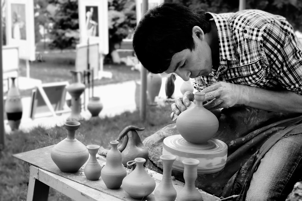 a man is making vases out of clay