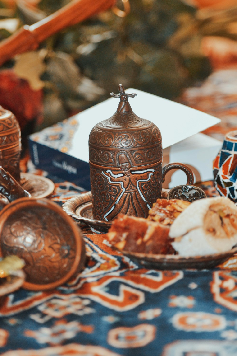 a table topped with a plate of food and a vase